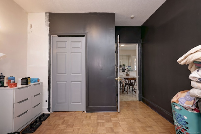 interior space featuring light parquet floors, a textured ceiling, and a closet