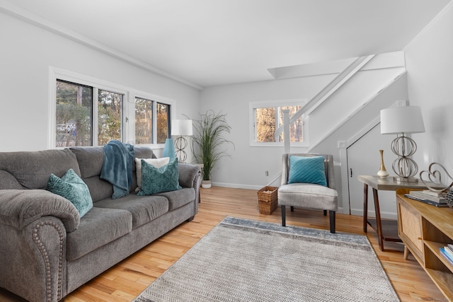 living room featuring stairs, baseboards, and wood finished floors