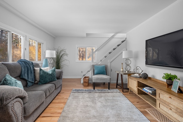 living room with stairway, baseboards, and wood finished floors