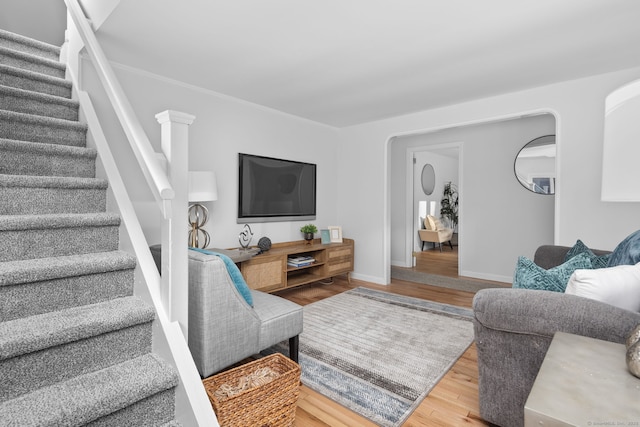 living room featuring stairs, wood finished floors, and baseboards