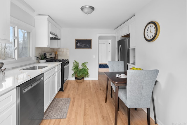 kitchen featuring a sink, appliances with stainless steel finishes, white cabinets, and under cabinet range hood