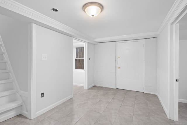 spare room featuring crown molding, light tile patterned floors, and baseboards