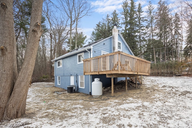 back of property featuring cooling unit, a wooden deck, and a chimney