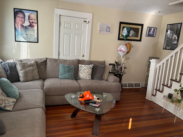 living room with dark hardwood / wood-style flooring and a textured ceiling