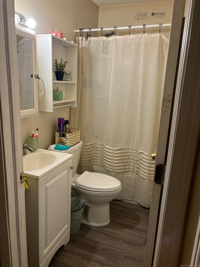 bathroom featuring toilet, vanity, hardwood / wood-style floors, and curtained shower