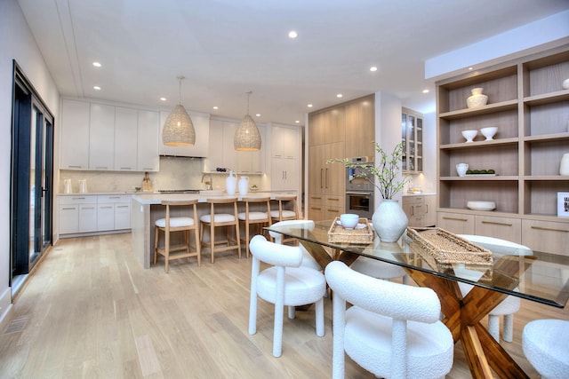 dining room featuring sink and light hardwood / wood-style floors