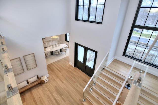 entryway featuring hardwood / wood-style flooring, a high ceiling, a wealth of natural light, and french doors