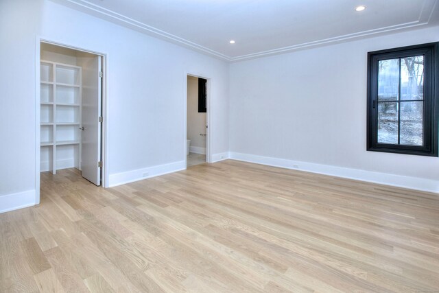 unfurnished room with crown molding and light hardwood / wood-style flooring