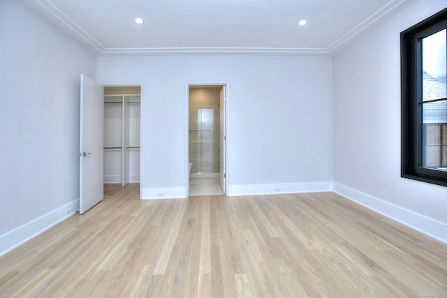 unfurnished bedroom featuring ensuite bath and light wood-type flooring