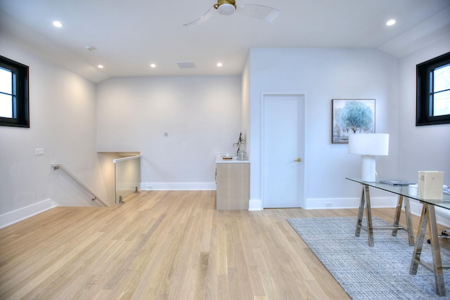 office area featuring ceiling fan, lofted ceiling, and light wood-type flooring