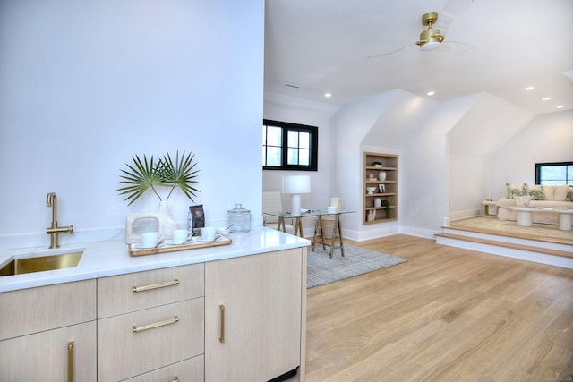 bar featuring lofted ceiling, sink, built in features, ceiling fan, and light hardwood / wood-style floors