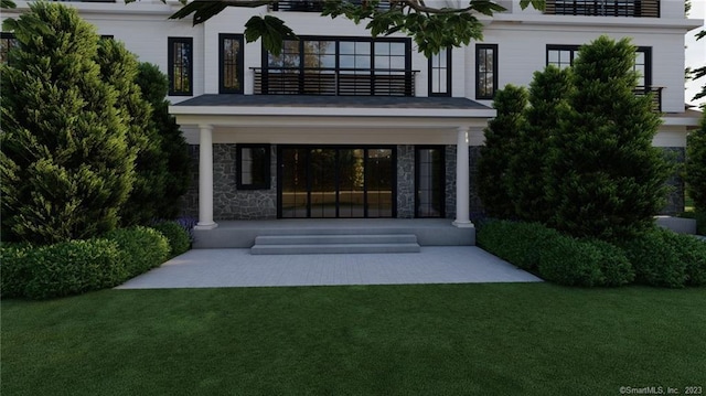 back of house with a balcony and a lawn