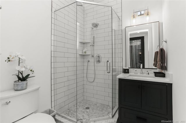 bathroom featuring vanity, toilet, and a shower with shower door