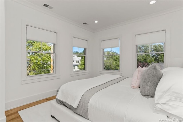 bedroom featuring wood-type flooring and ornamental molding