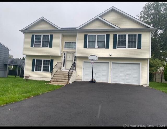 split foyer home with a front yard and a garage