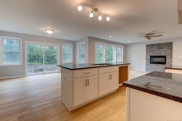 kitchen featuring light wood-type flooring, white cabinetry, and a healthy amount of sunlight