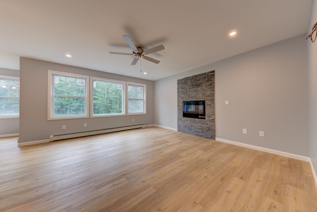 unfurnished living room featuring a stone fireplace, ceiling fan, a baseboard radiator, and light hardwood / wood-style floors