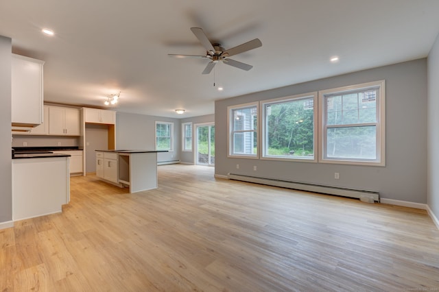 kitchen with a center island, white cabinets, light hardwood / wood-style flooring, ceiling fan, and a baseboard radiator