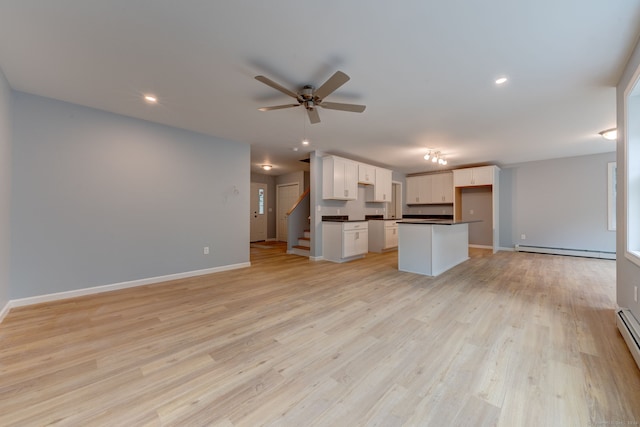 kitchen with ceiling fan, a baseboard radiator, a kitchen island, light hardwood / wood-style flooring, and white cabinets