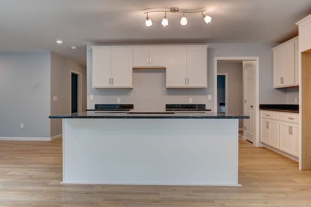 kitchen featuring white cabinetry, a kitchen island, and light wood-type flooring