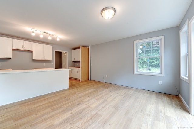 kitchen with light wood-type flooring and white cabinetry