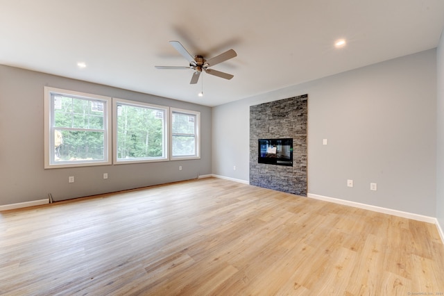 unfurnished living room featuring a fireplace, light wood-type flooring, and ceiling fan