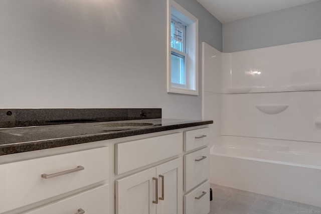 bathroom with a tub and vanity