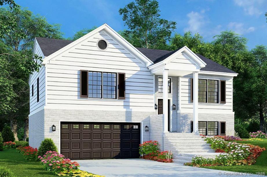 bi-level home featuring a garage, concrete driveway, and brick siding