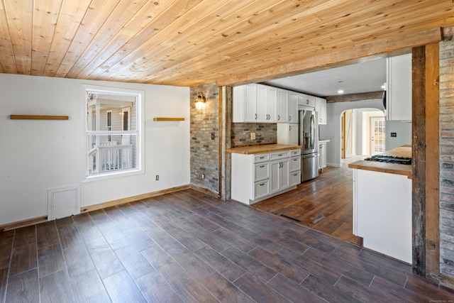 kitchen featuring butcher block counters, white cabinetry, dark wood-type flooring, wood ceiling, and appliances with stainless steel finishes