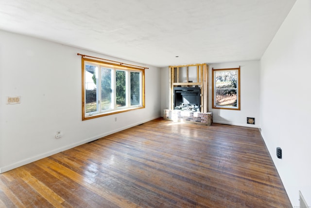 unfurnished living room with a wealth of natural light and dark hardwood / wood-style floors