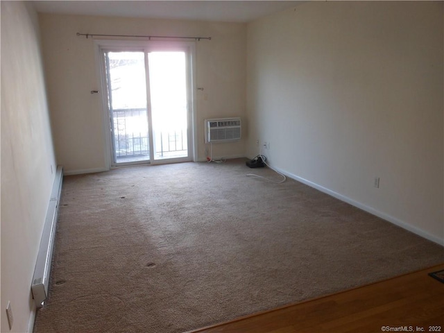 carpeted spare room with a wall unit AC and a baseboard heating unit