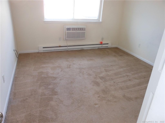 spare room with a baseboard radiator, a wall mounted air conditioner, and light colored carpet