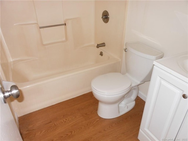 full bathroom featuring vanity, hardwood / wood-style flooring,  shower combination, and toilet