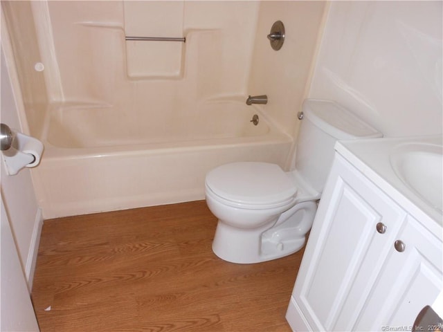 full bathroom featuring vanity, hardwood / wood-style flooring, shower / washtub combination, and toilet