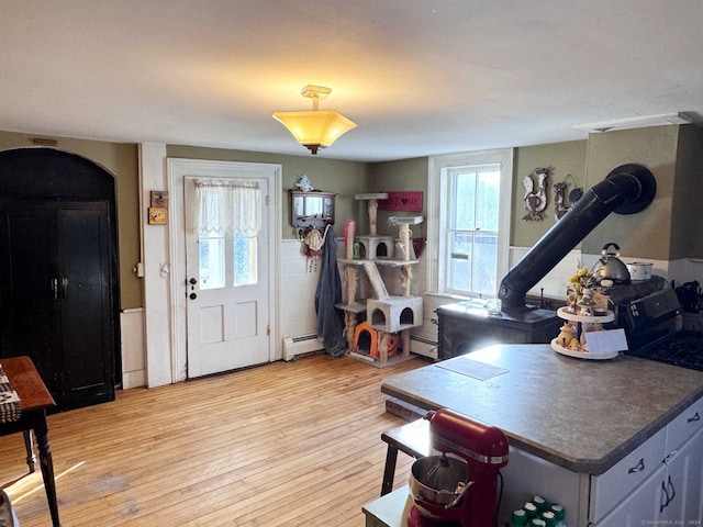 373 Main St, New Hartford, CT 06057 - entryway featuring a wood stove, a baseboard heating unit, and light wood-type flooring
