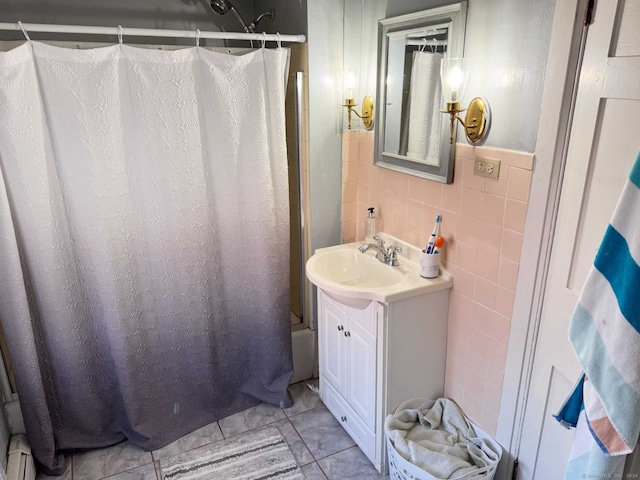 bathroom featuring vanity, shower / bathtub combination with curtain, tile patterned floors, and tile walls