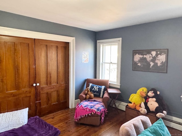 bedroom featuring a baseboard radiator and dark hardwood / wood-style floors