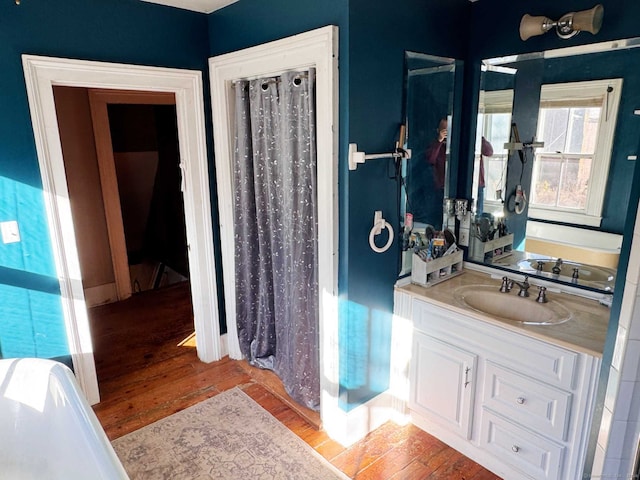 bathroom featuring a bath, wood-type flooring, and vanity