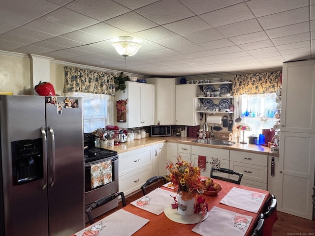 kitchen featuring plenty of natural light, white cabinets, and appliances with stainless steel finishes