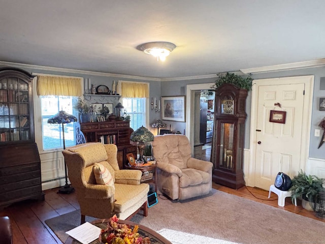 living room featuring wood-type flooring, ornamental molding, a baseboard heating unit, and a healthy amount of sunlight