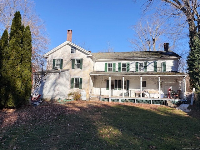 back of property featuring a porch and a lawn