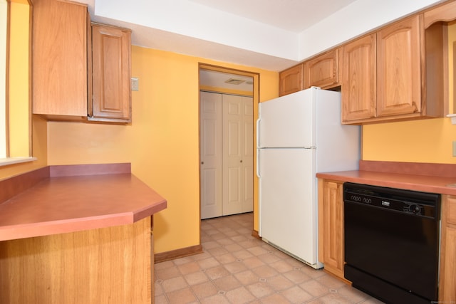 kitchen with light brown cabinetry, dishwasher, and white refrigerator