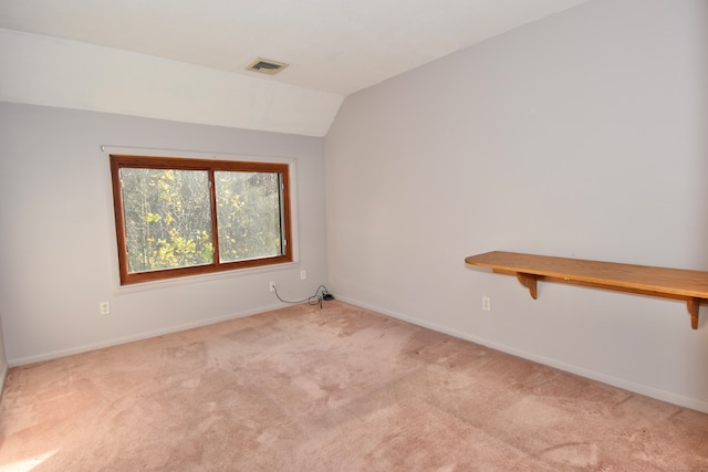 carpeted spare room featuring lofted ceiling