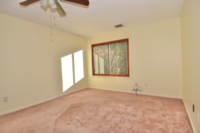 spare room with ceiling fan and light colored carpet