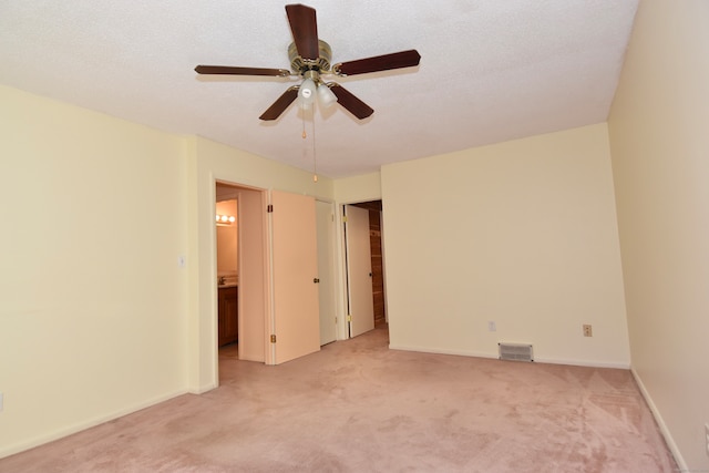 unfurnished room featuring a textured ceiling, light colored carpet, and ceiling fan