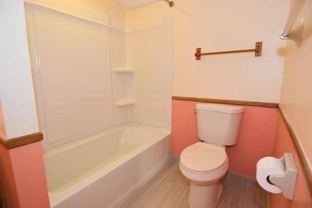 bathroom with hardwood / wood-style flooring, toilet, and shower / bathtub combination