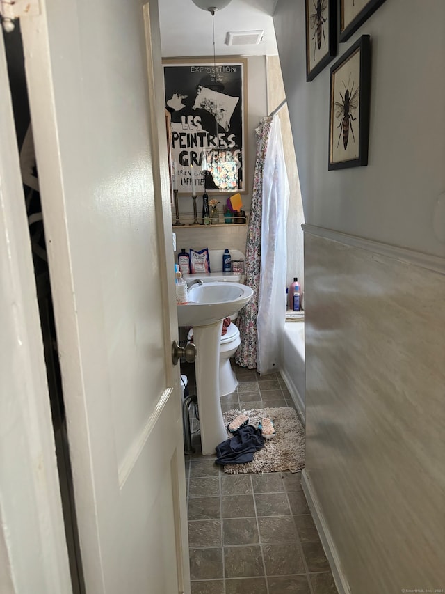 bathroom featuring tile patterned flooring and shower / tub combo with curtain