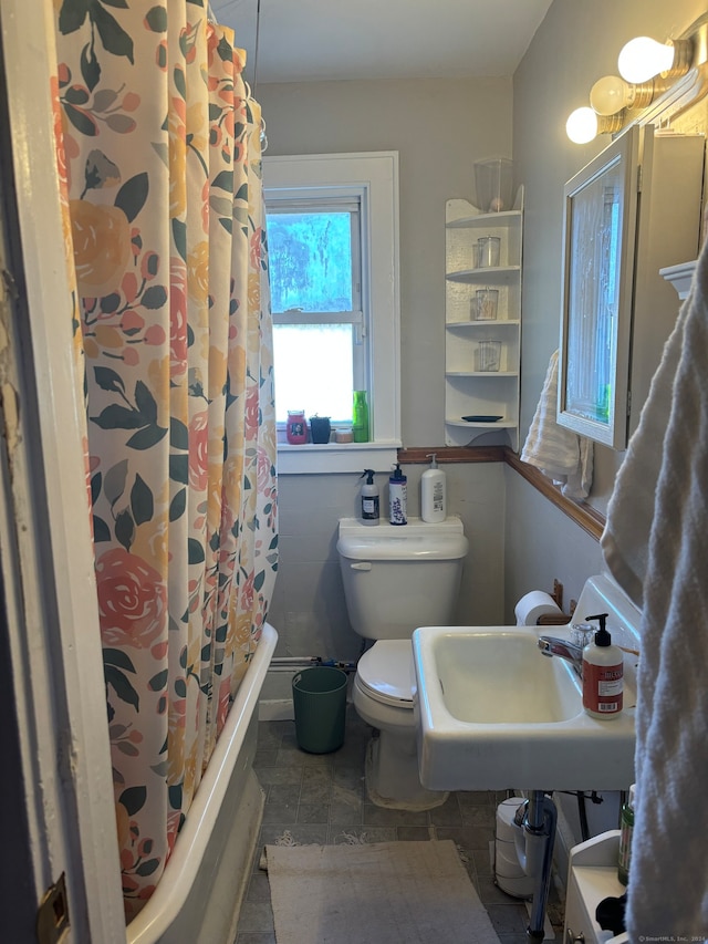 full bathroom with toilet, shower / bath combo with shower curtain, and sink