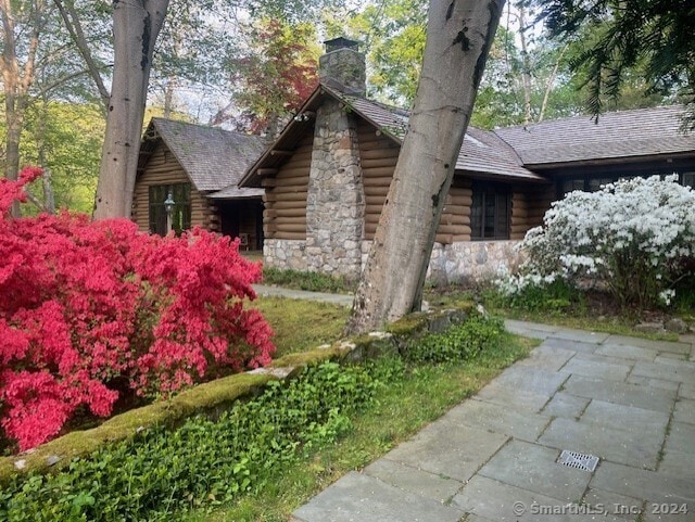 87 Red Coat Rd, Westport, CT 06880 - view of home's exterior featuring log siding, a chimney, and stone siding