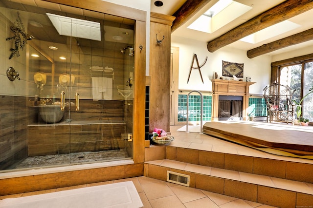 87 Red Coat Rd, Westport, CT 06880 - bathroom with a shower stall, a fireplace, tile patterned flooring, beamed ceiling, and a skylight